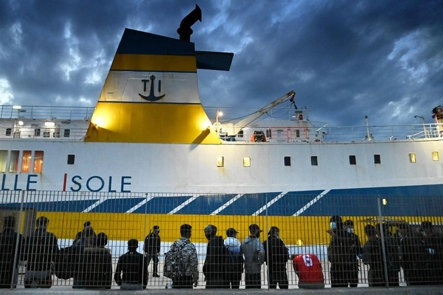 Migrantes de Túnez y Libia, que llegaron a la isla italiana de Lampedusa la semana pasada hacen fila en un centro de ayuda. Foto Afp 