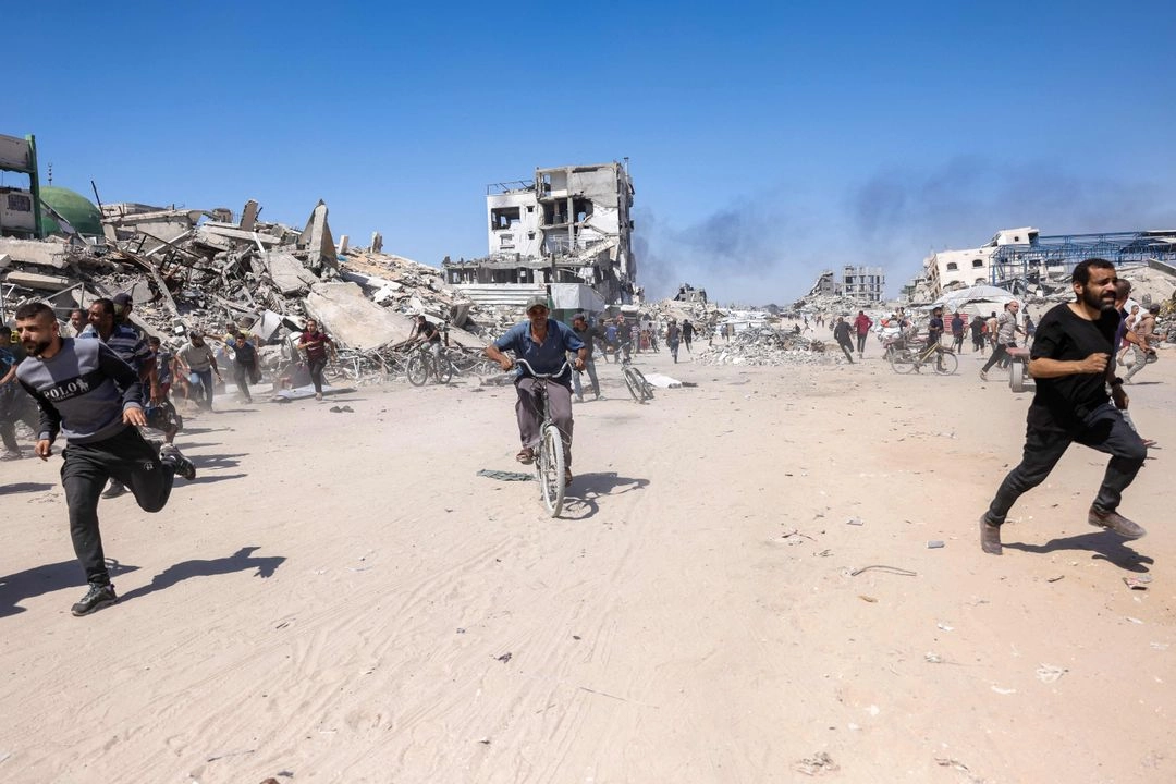 Palestinos corren para refugiarse por un ataque israelí en Jabalia, en el norte de la Franja de Gaza, el 23 de mayo de 2025. 