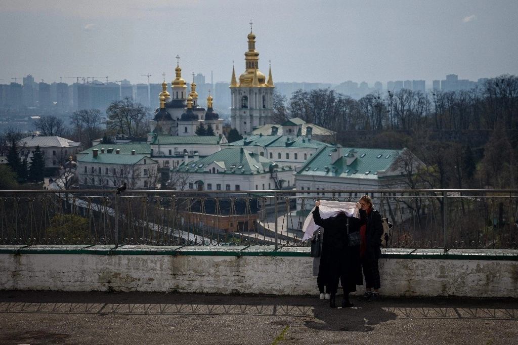 Mujeres caminan en las inmediaciones de la Iglesia del Refectorio de San Antonio y Teodosio durante un servicio ortodoxo del Domingo de Ramos en Kiev, Ucrania, el 9 de abril de 2023. Foto Afp
