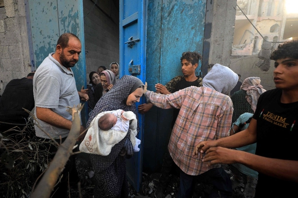 Palestinos escapan de los bombardeos aéreos israelíes en un campo de refugiados en la Franja de Gaza. Foto Afp