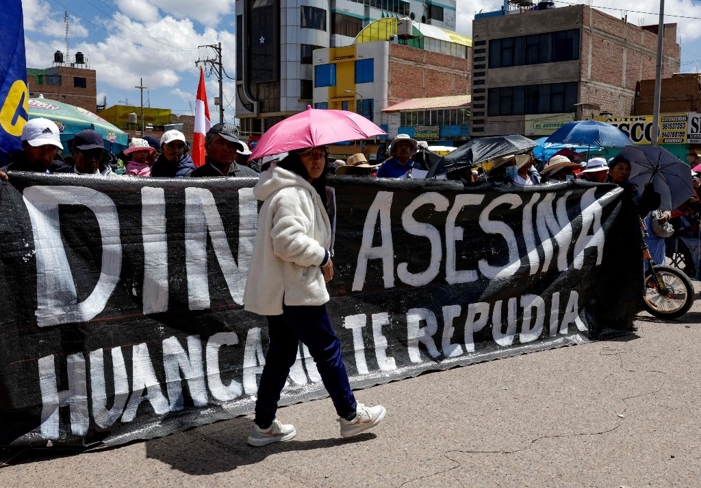Manifestantes sostienen una pancarta que llama asesina a la presidenta peruana Dina Boluarte durante el primer aniversario de las violentas manifestaciones en Juliaca, en Puno. Región en el sur de Perú, el 9 de enero de 2024. Foto Afp