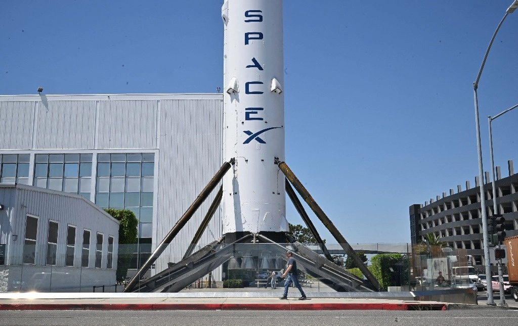 Un peatón pasa junto al cohete Falcon 9 en la sede de SpaceX en Hawthorne, California, el 16 de julio de 2024. Foto Afp