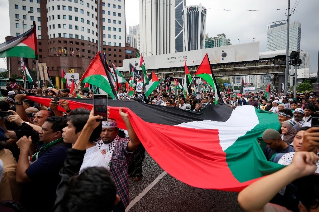Musulmanes malasios ondean banderas palestinas durante una manifestación para mostrar su apoyo al pueblo palestino, mientras marchan hacia la embajada de EU en Kuala Lumpur, Malasia, el viernes 20 de octubre de 2023. Foto Ap