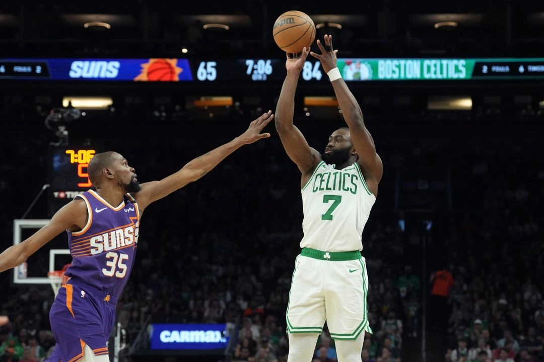 El base de los Celtics de Boston, Jaylen Brown (7), lanza un triple sobre el alero de los Suns de Phoenix, Kevin Durant (35), en la segunda mitad del partido de la NBA, el 26 de marzo de 2025. Foto 
