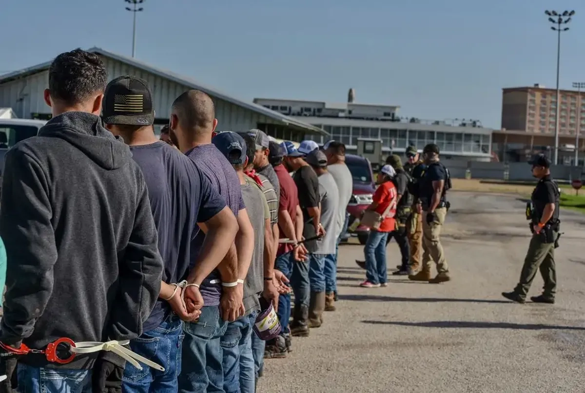Migrantes esposados ​​tras ser arrestados por agentes del ICE en el estado de Luisiana, EU. Foto