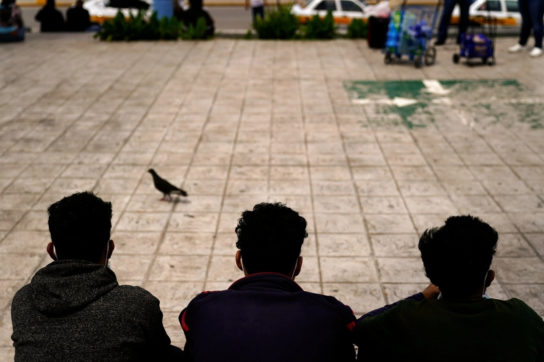 Migrantes hondureños sentados en una plaza de la fronteriza ciudad de Reynosa, Tamaulipas, después de ser devueltos por Estados Unidos a territorio mexicano, el 13 de mayo de 2021. Foto Ap
 