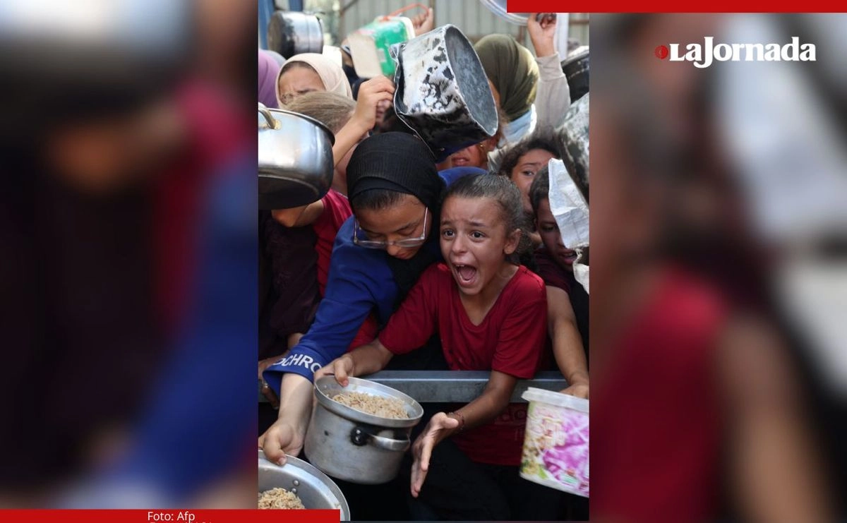Mujeres y niños gazatíes se arremolinan para recibir alimentos en un comedor de una organización humanitaria en el campamento de refugiados de Nuseirat, en Gaza. El Unicef advirtió que la desnutrición infantil aguda en la ciudad va en aumento.
