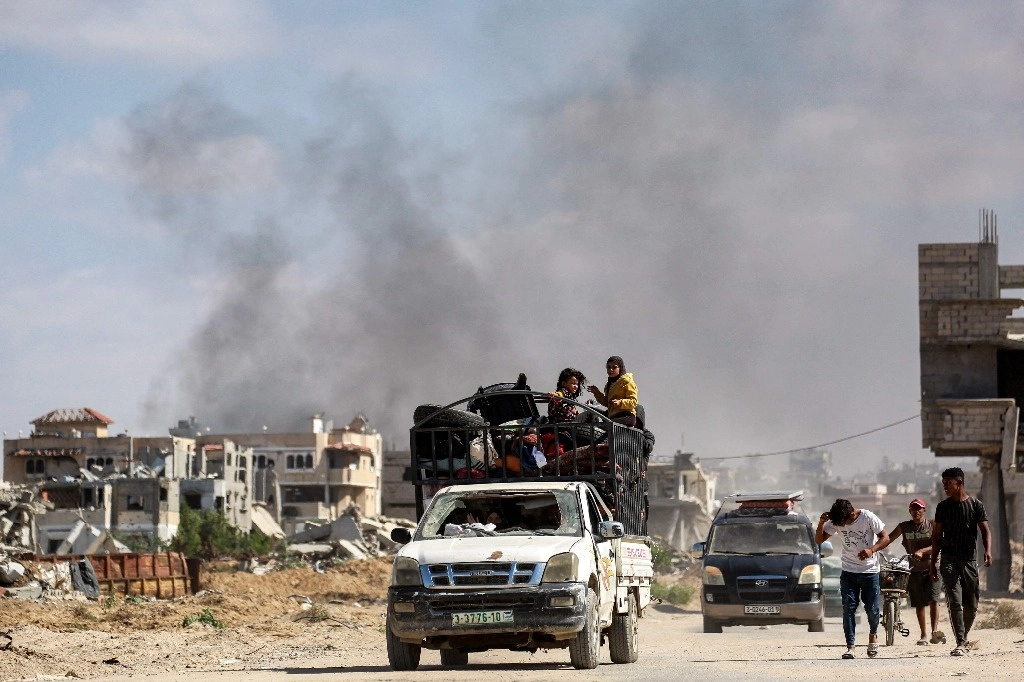 Los niños viajan con muebles en la parte trasera de un camión mientras las personas desplazadas llegan a Khan Yunis después de recibir el aviso de las fuerzas israelíes de evacuar las partes orientales de la ciudad en el sur de la Franja de Gaza el 7 de octubre de 2024, en el primer aniversario de la guerra en curso en el territorio palestino entre Israel y Hamás. Foto Afp
