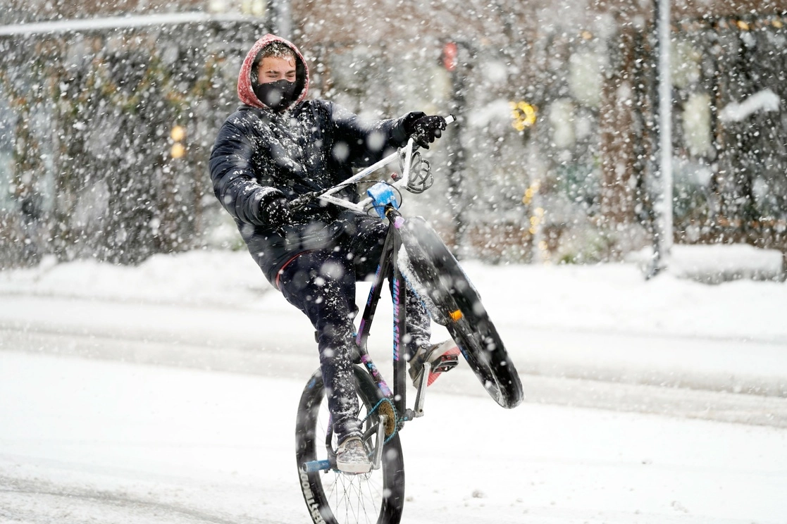 Un hombre pasea en bicicleta bajo una fuerte nevada en North Street en Pittsfield, Massachusetts. Foto Ap