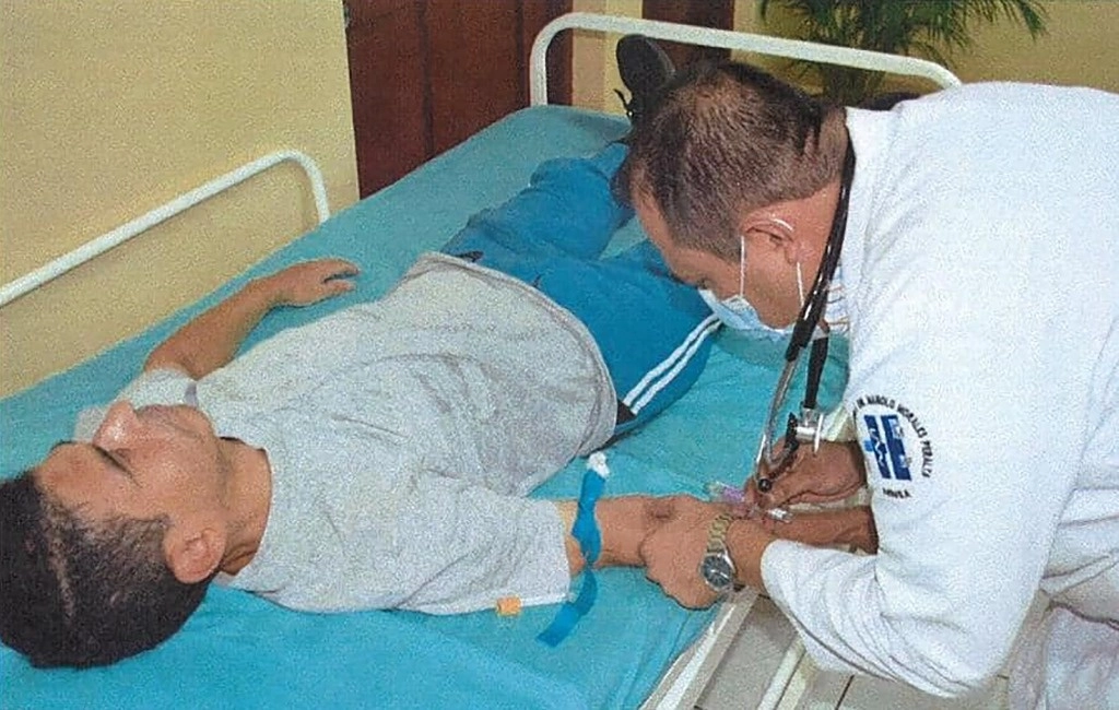 Imagen publicada por el Canal 4 oficial de Nicaragua a través de su cuenta de Facebook el 28 de noviembre de 2023, que muestra al obispo nicaragüense Rolando Álvarez (i), un fuerte crítico del presidente Daniel Ortega, siendo examinado por un médico en la prisión La Modelo en Tipitapa, al este de Managua. Foto Afp