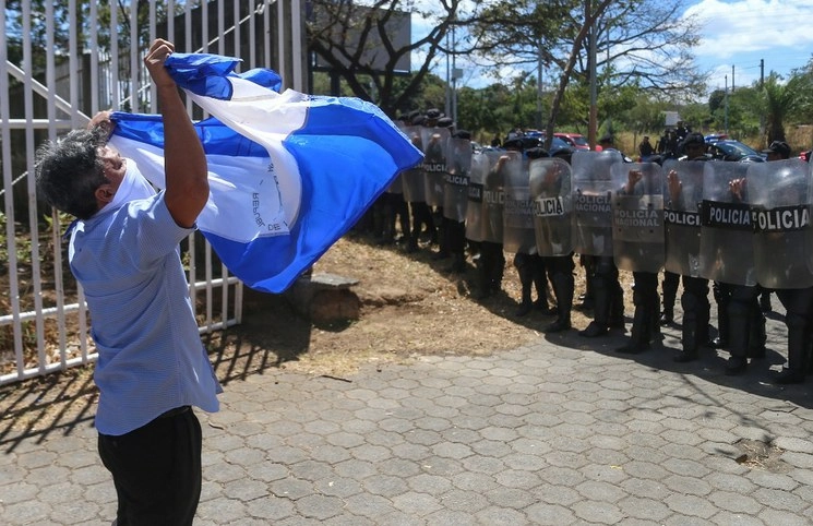 Un hombre protesta frente a los policías que rodearon la Catedral. Foto Afp