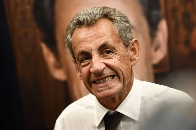 El ex presidente francés Nicolas Sarkozy sonríe mientras firma copias de su último libro. Foto Afp