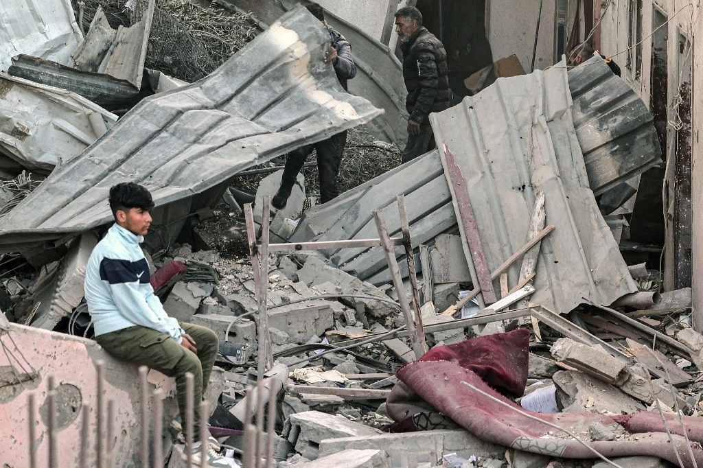 Un joven palestino observa la destrucción a su alrededor tras los ataques aéreos israelíes nocturnos en el campo de refugiados de Rafá, en el sur de la franja de Gaza, el 22 de febrero de 2024. Foto Afp