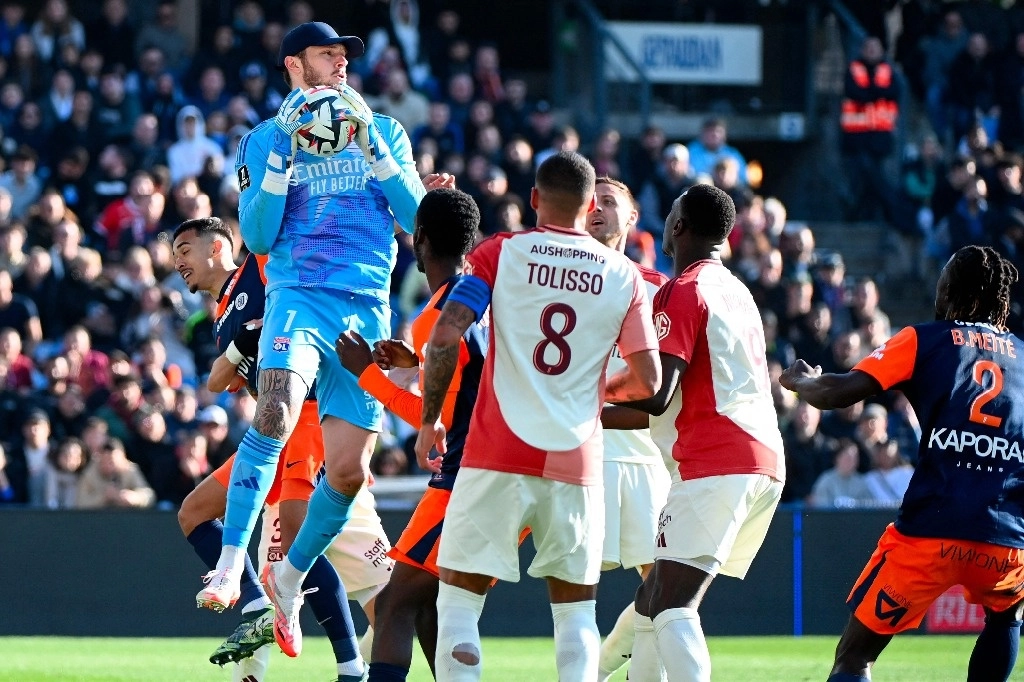 El portero brasileño #23 del Lyon, Lucas Perri (izq.), agarra el balón durante el partido de fútbol de la L1 francesa entre Montpellier Herault SC y Olympique Lyonnais (OL) en el Stade de la Mosson en Montpellier, sur de Francia, el 16 de febrero de 2025. Foto Afp