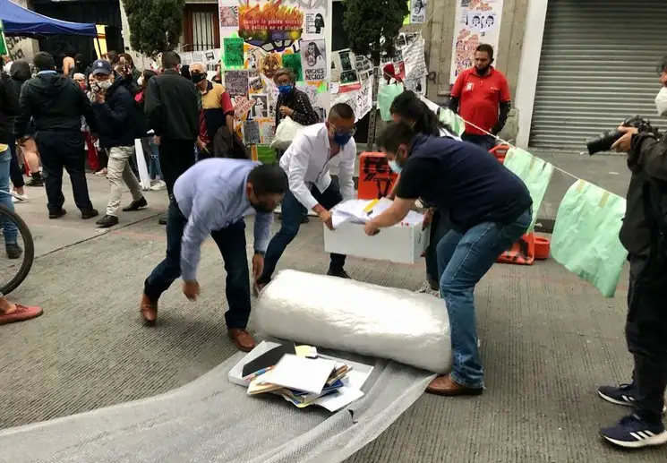 Trabajadores de la CNDH recogen  archivos que sacaron las manifestantes que mantienen tomadas las instalaciones del organismo en el Centro Histórico.  Foto: Roberto García  