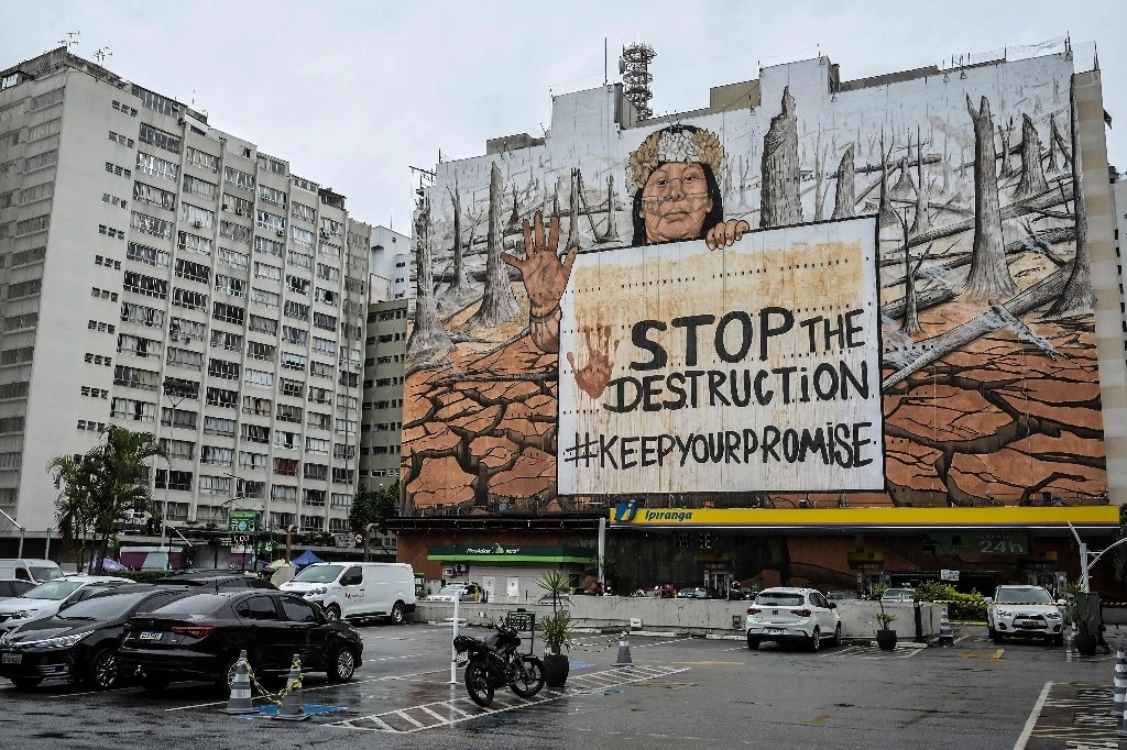 Mural callejero creado por el artista brasileño Mundano y hecho con cenizas de incendios forestales y lodo de inundaciones para resaltar los fenómenos meteorológicos extremos que causan estragos en todo el país, en Sao Paulo, Brasil. Foto AFP