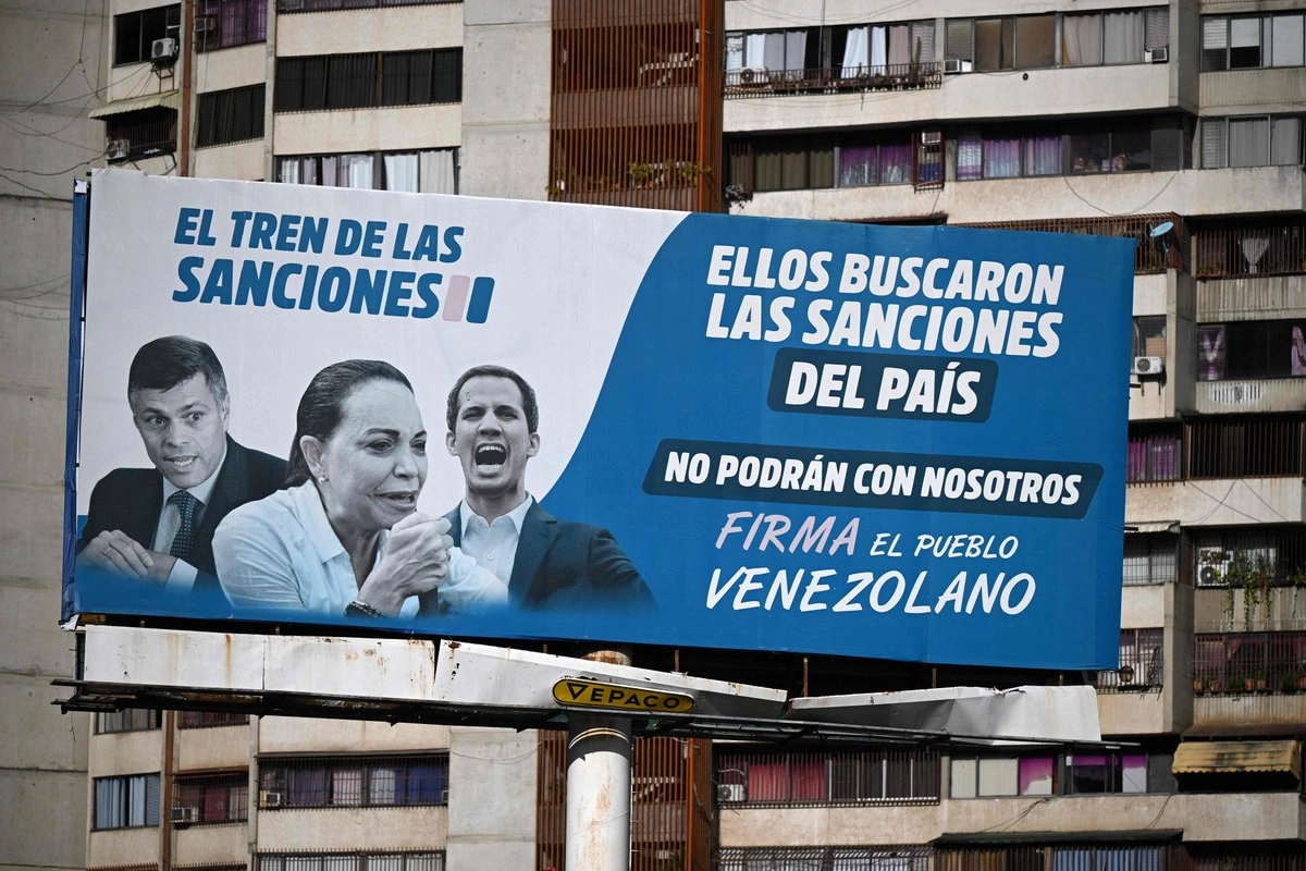 Una valla publicitaria acusa a los líderes opositores (de izquierda a derecha) Leopoldo López, María Corina Machado y Juan Guaidó por las sanciones impuestas por Estados Unidos al país, en Caracas el 10 de octubre de 2025, tras la concesión del Premio Nobel de la Paz a Machado. Foto