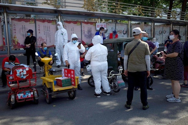 Personal de Salud en China realiza pruebas de detección de Covid-19 a personas que visitaron el mercado Xinfadi, en Pekín. Foto Afp