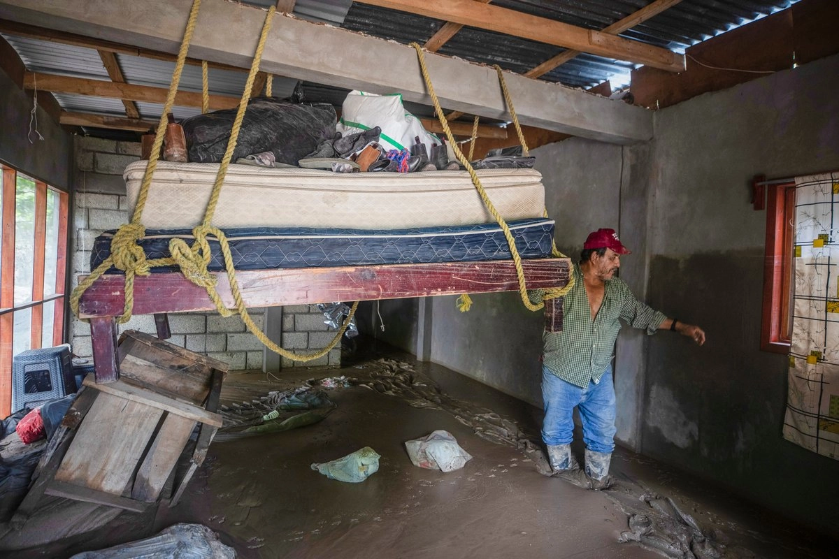 Un hombre de la localidad Oxitempa, en Veracruz, resguarda sus pertenencias amarradas al techo de su domicilio. Foto 
