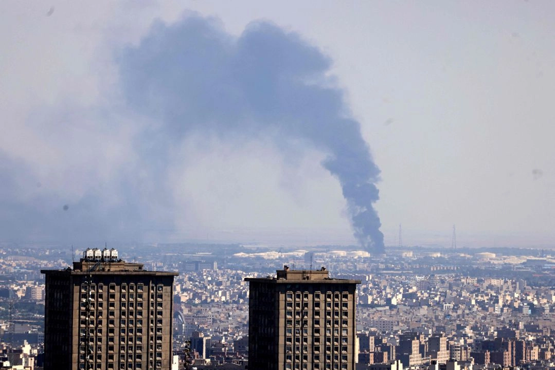 Columnas de humo se elevan a lo lejos desde una refinería de petróleo tras un ataque israelí a la capital iraní, Teherán, el 17 de junio de 2025.