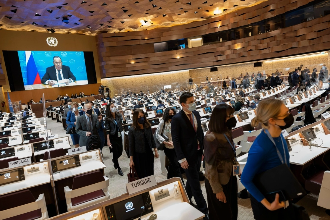 Embajadores y diplomáticos abandonan la sala mientras el ministro de Relaciones Exteriores de Rusia, Sergei Lavrov (en la pantalla), se dirige con un mensaje de video pregrabado a la Conferencia de Desarme en Ginebra, Suiza, el martes 1 de marzo de 2022. Foto Afp