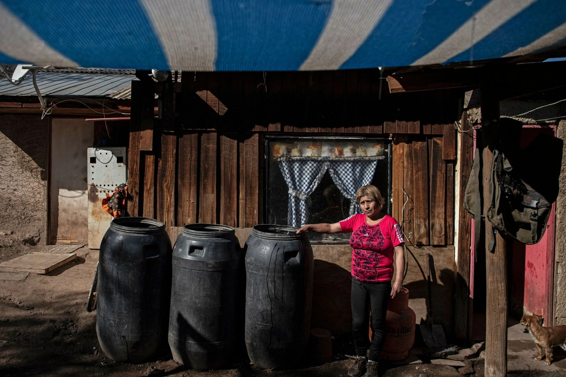 Una residente en la localidad de Tiltil, Chile, donde el acceso al agua es difícil debido a que los ríos y pozos subterráneos se han secado por falta de lluvias, pero también por la presencia de empresas mineras y agroindustriales que la sobreexplotan. Foto Afp