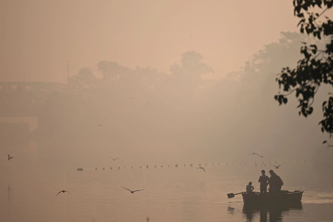 Personas disfrutan de un paseo en bote por el río Yamuna, entre la niebla y la contaminación, tres días atrás en Nueva Delhi, India, el 21 de noviembre de 2021. Foto Afp
