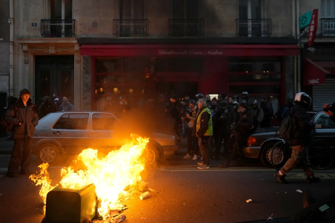 Contenedores de basura se incendian durante una protesta contra la reforma de pensiones, hoy en París. Foto Ap