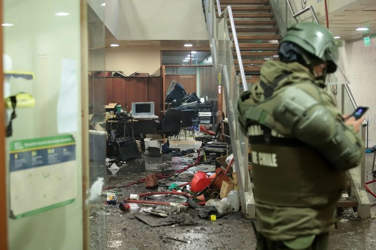 La policía vigila el interior del municipio de Curacautín después de que fue destruido durante las protestas en la región de la Araucanía, al sur de Chile. Foto Afp
