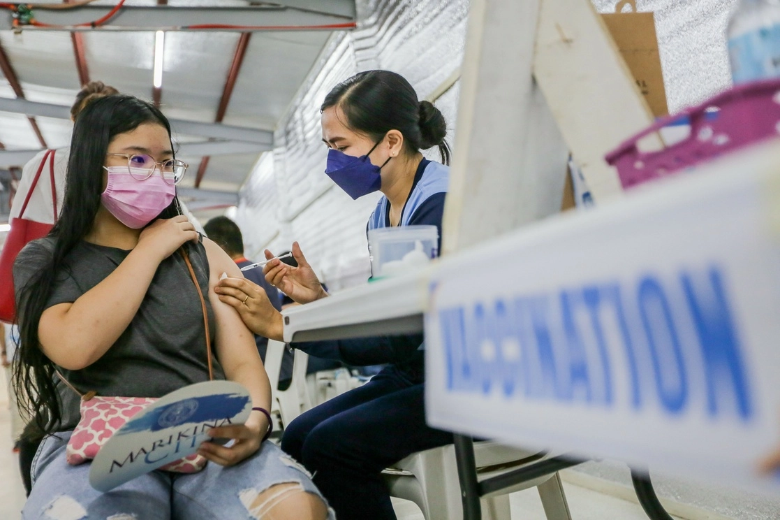 Una niña es inoculada con una vacuna contra la Covid-19 en un complejo deportivo, en la Ciudad de Marikina, Filipinas, este día. Foto Xinhua