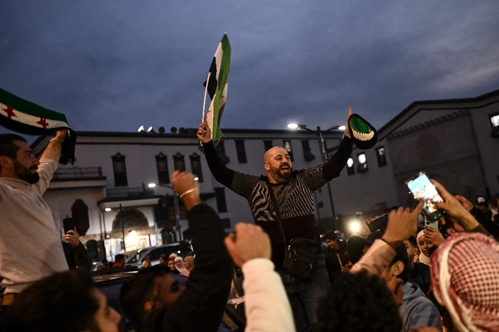 Personas celebran la caída del régimen sirio a manos del grupo rebelde Hayat Tahrir al Sham. Foto Afp