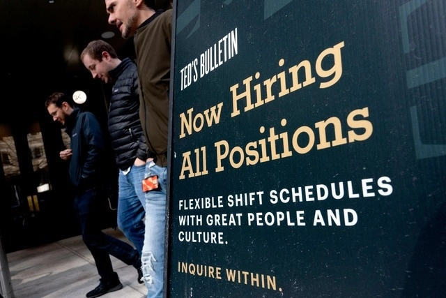 Peatones pasan junto a un cartel que dice "Ahora contratando" en Arlington, Virginia. Foto Afp