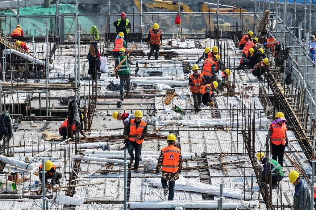 Trabajadores en la azotea de un edificio residencial en construcción en Nanjing, en la provincia de Jiangsu, en el este de China, el 7 de marzo de 2024. Foto Afp