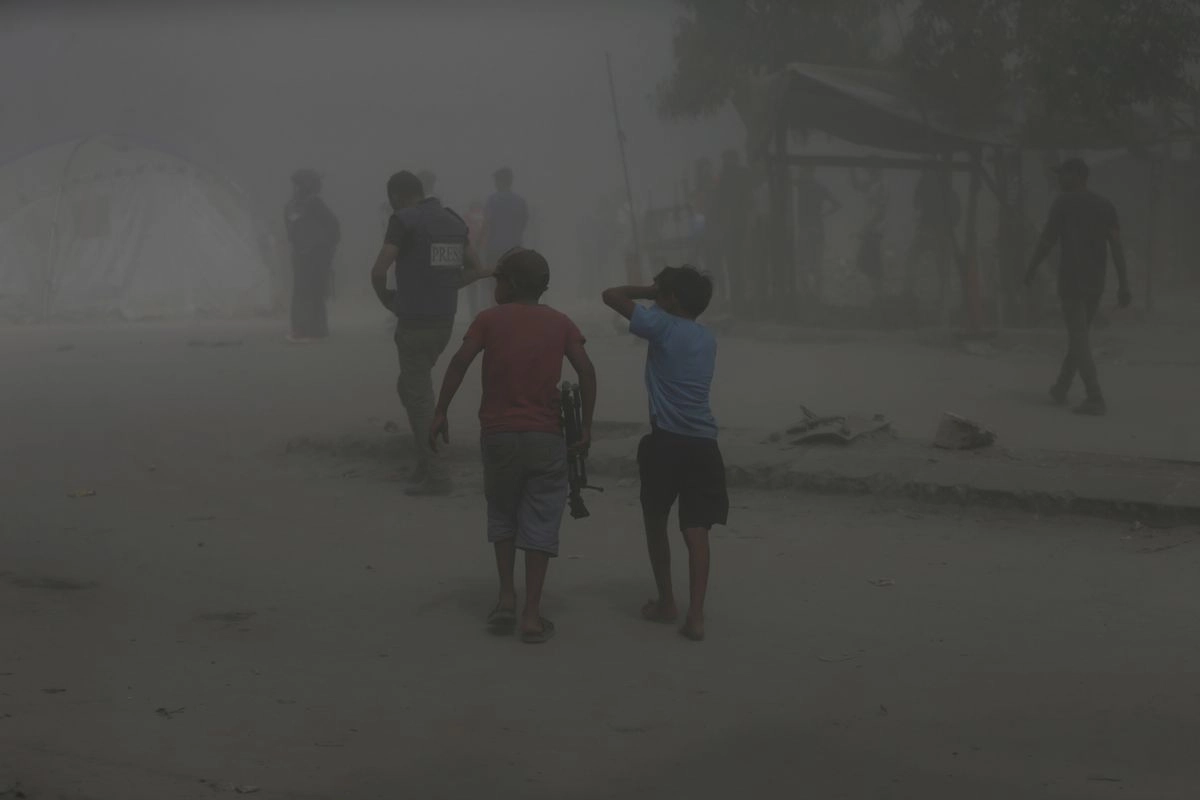 Palestinos caminan entre el polvo momentos después de que un ataque militar israelí destruyera un edificio en la ciudad de Gaza el lunes 15 de septiembre de 2025.