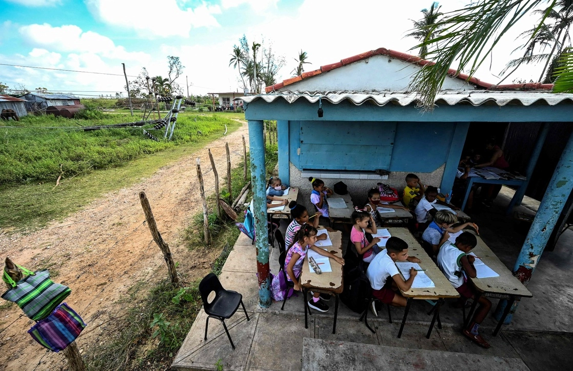 Estudiantes cubanos reciben clases en el patio de una casa en La Coloma, provincia de Pinar del Río, una de las regiones más afectadas tras el paso del huracán 'Ian'. Foto Afp.