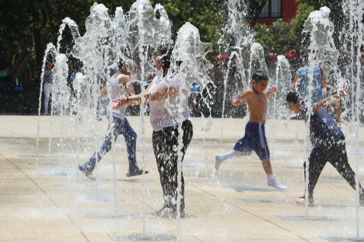 Capitalinos menguan las altas temperaturas que se registran en la urbe con el agua de la fuente del Monumento a la Revolución, ubicado en la alcaldía Cuauhtémoc. Foto María Luisa Severiano / Archivo
