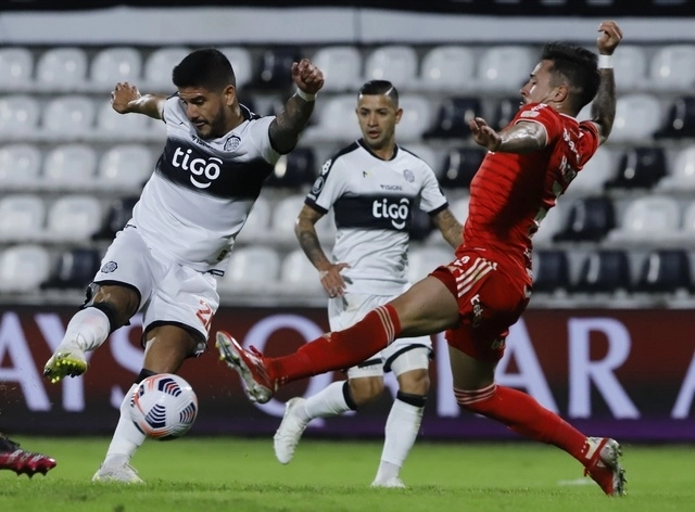 Isidro Pitta del Olimpia (izq) disputa la esférica con el jugador del Inter, Heitor (der). Foto Ap