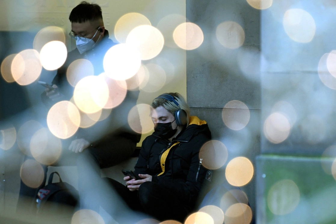 Dos personas esperan a ser vacunados contra el Covid-19, en Manchester, al noroeste de Inglaterra, el 14 de diciembre de 2021. Foto Afp 