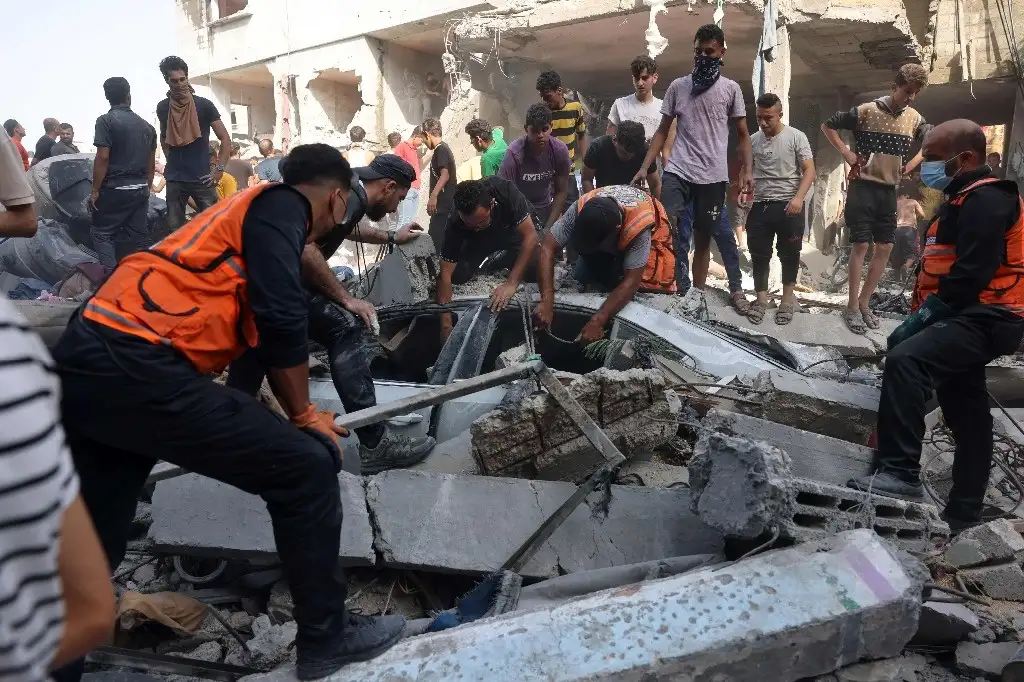 Rescatistas sacan de entre los escombros a víctimas de los intensos bombardeos en la ciudad de Rafá. Foto Afp



