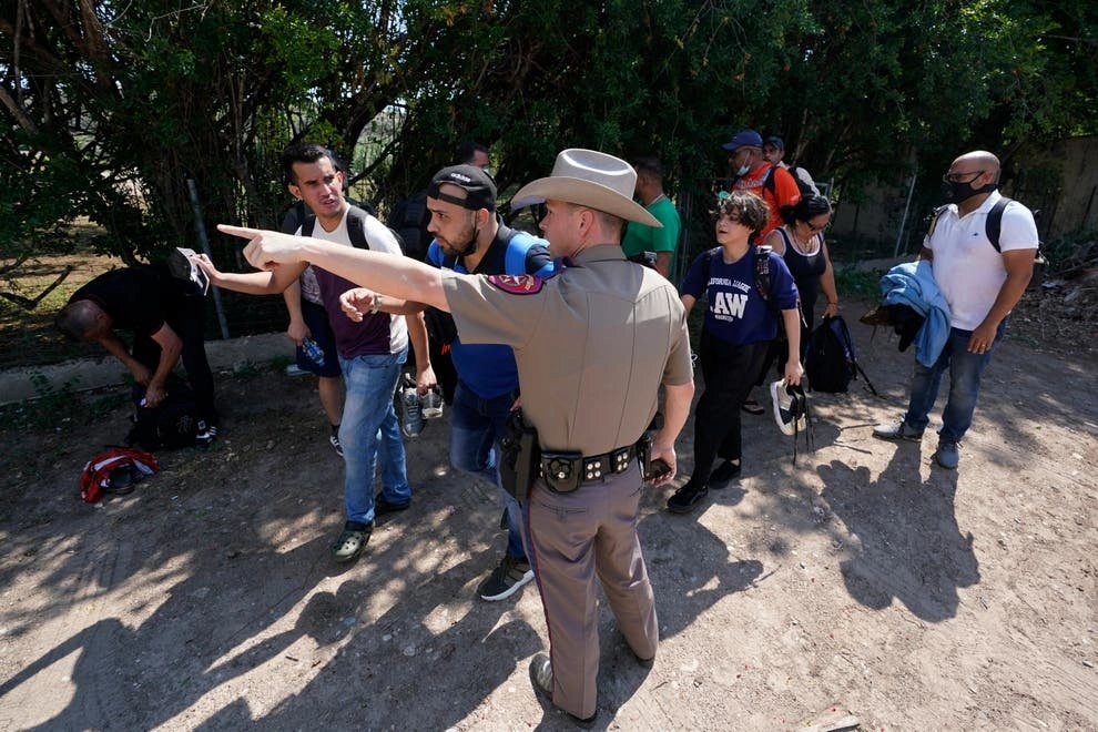 En imagen de junio pasado, un oficial de Texas da indicaciones a un grupo de indocumentados que se entregó a las autoridades. Un decreto sanitario firmado por Donald Trump en 2020 permite a EU expulsar a migrantes que ingresen a su territorio, por el temor a la propagación del Covid-19. Foto Ap