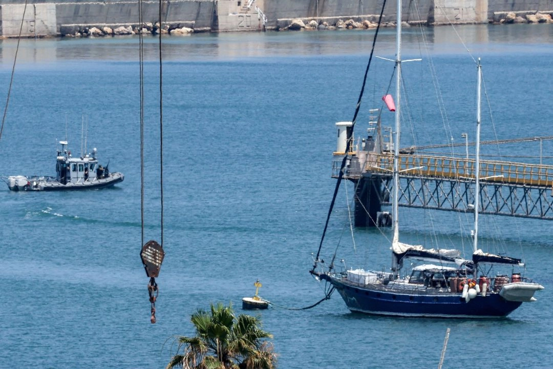 Una lancha patrullera israelí se acerca al velero de ayuda Madleen, amarrado en el puerto sureño de Ashdod el 10 de junio de 2025, tras ser interceptado el día anterior por fuerzas israelíes.