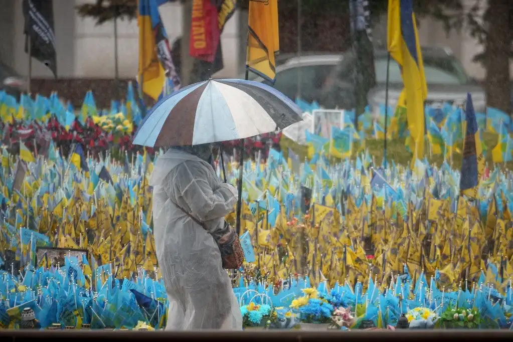 Una mujer camina junto a un memorial a los soldados caídos en Kiev, Ucrania. Foto Ap