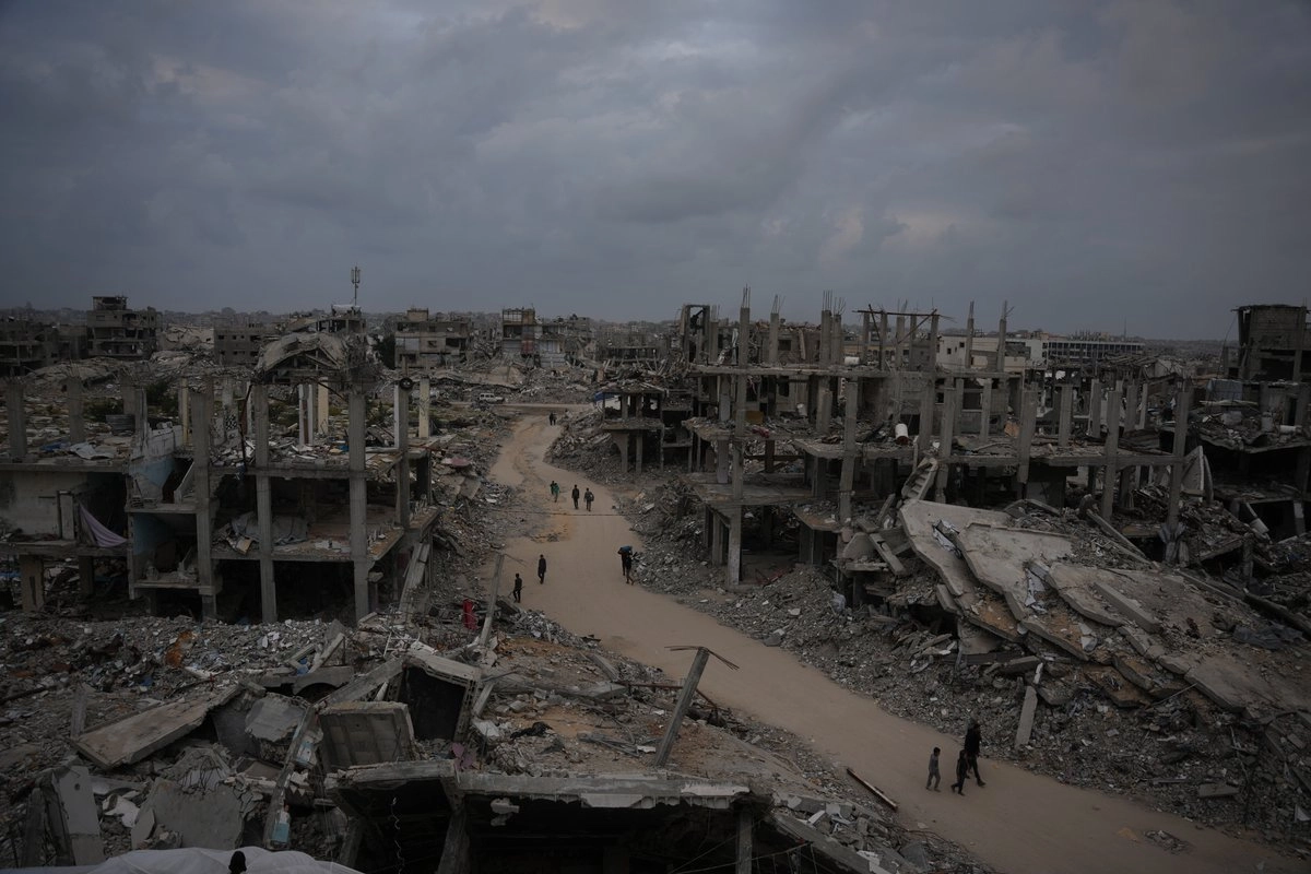 Palestinos caminan por una calle en Jabaliya, en el norte de la Franja de Gaza, el 6 de diciembre de 2025.