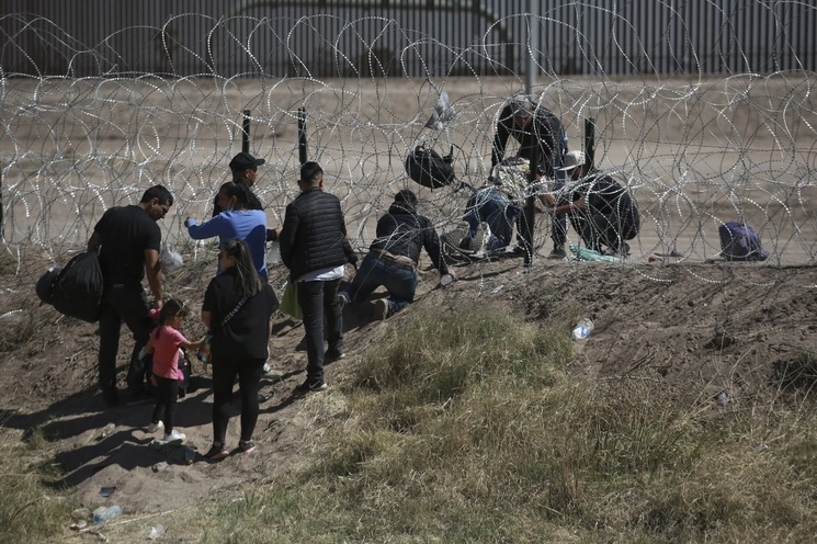 Migrantes cruzan una cerca de alambre de púas hacia Estados Unidos desde Ciudad Juárez, el 9 de mayo de 2023. Foto Ap