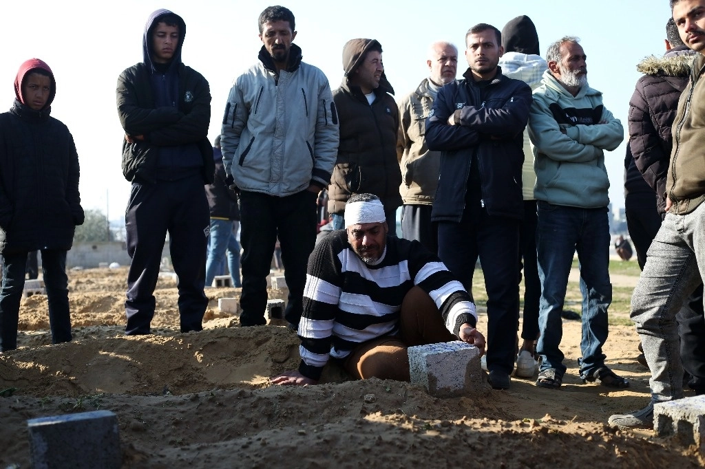 Palestinos alrededor de la tumba de un familiar muerto durante un bombardeo israelí en Jan Yunis, en la franja de Gaza, el 26 de febrero de 2024. Foto Ap