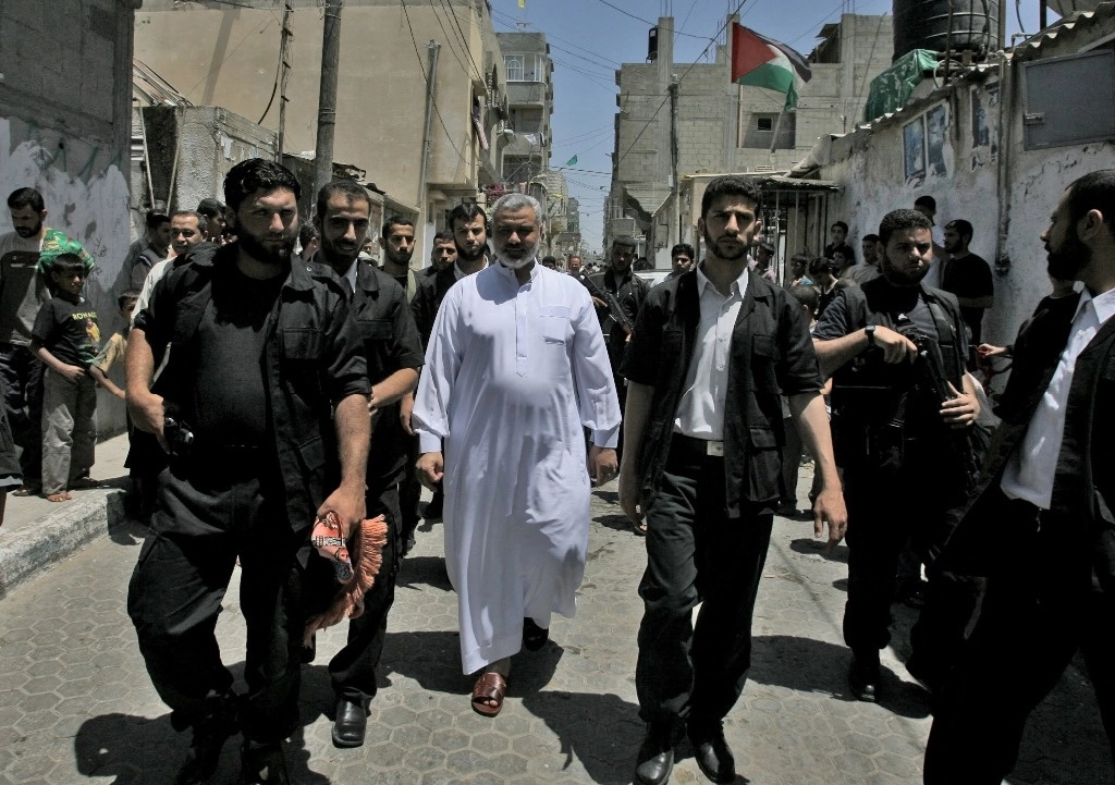  El primer ministro palestino, Ismail Haniyeh (centro), camina por las calles del campo de refugiados de Al-Shati, en la ciudad de Gaza, después de asistir a la oración semanal del viernes al mediodía, el 16 de junio de 2006. Foto Afp