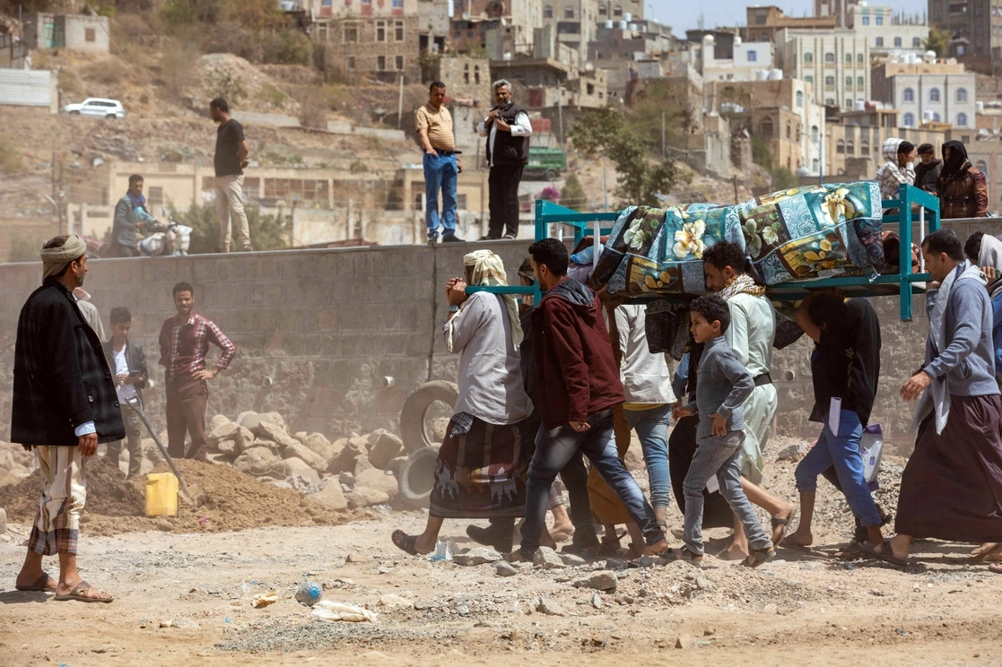 Un grupo de personas cargan el cuerpo de otra fallecida en un ataque con proyectiles de mortero durante los combates entre los rebeldes hutíes y las fuerzas yemeníes leales al gobierno respaldado por Arabia Saudita, en la tercera ciudad de Taez, Yemen, el 26 de febrero de 2022. Foto Afp