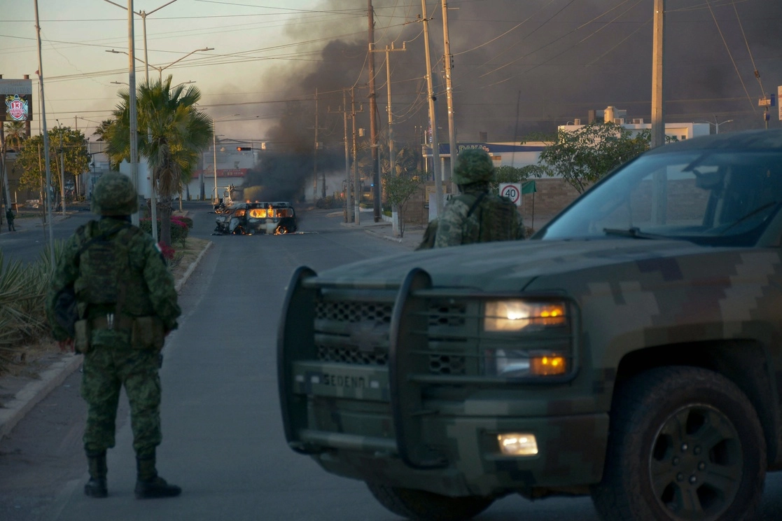 Soldados mexicanos montan guardia cerca de vehículos en llamas en una calle durante el  operativo de captura Ovidio Guzmán, hijo de 'El Chapo', en Culiacán, Sinaloa, ayer 5 de enero de 2023. Foto AFP