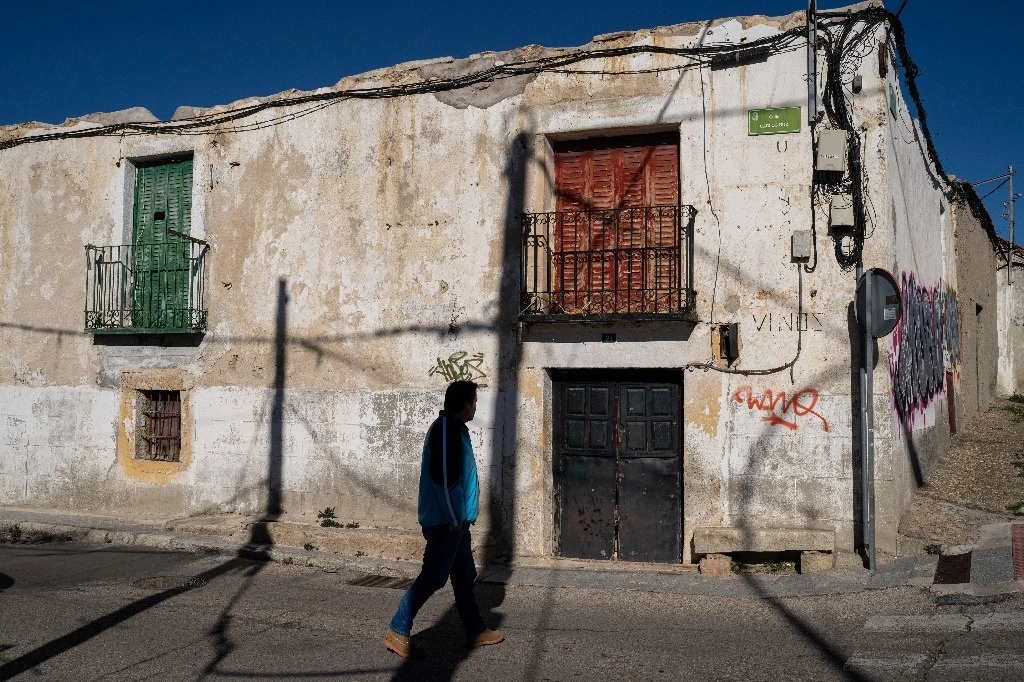 Un hombre pasa junto a una casa abandonada en el pueblo de La Cabrera, en las afueras de Madrid, España, el martes 14 de enero de 2025. Foto Ap