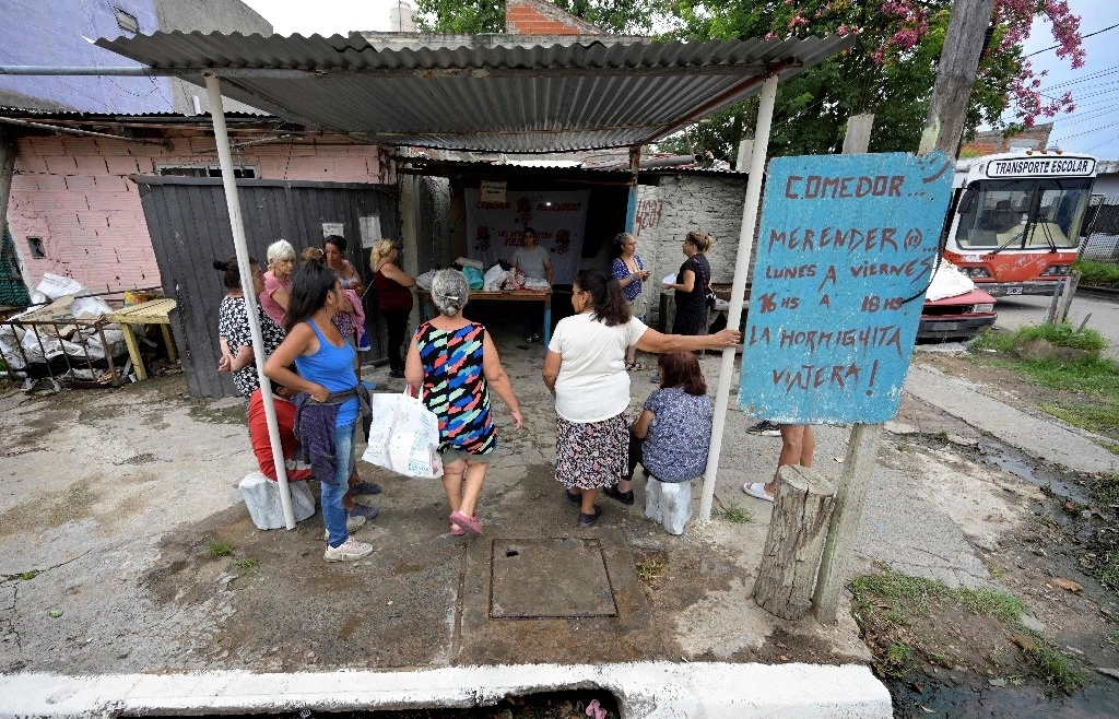 Personas hacen cola para dejar sus bolsas con envases de plástico vacíos en el comedor social "Las Hormiguitas Viajeras" para recibir una comida gratis en Loma Hermosa, provincia de Buenos Aires, el 9 de febrero de 2024. Foto Afp
